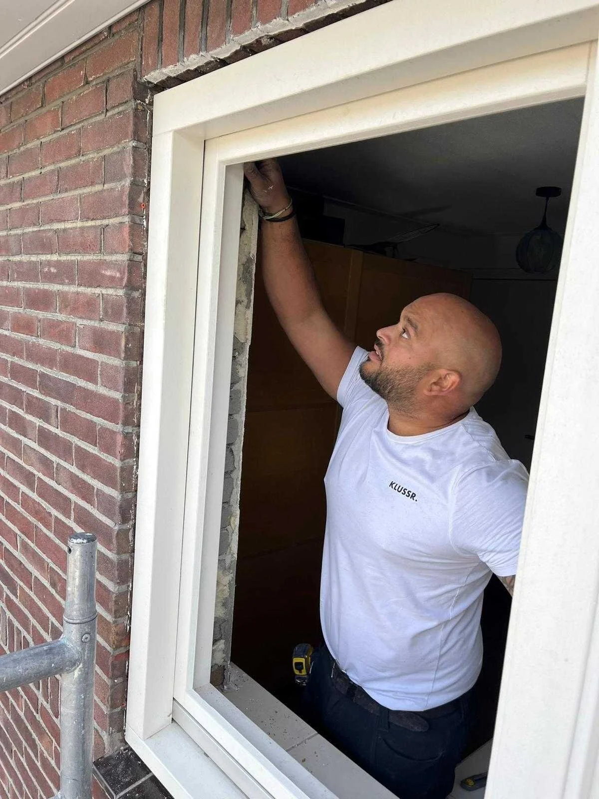Vakman van KLUSSR. plaatst een kozijn